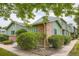 Angle view of charming green-sided home with brick accents and lush landscaping at 400 S Balsam St, Lakewood, CO 80226