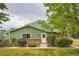 Charming exterior view of home with brick and green siding plus manicured lawn and landscaping at 400 S Balsam St, Lakewood, CO 80226