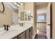 Well-lit bathroom featuring a double vanity, modern fixtures and a view into the hallway at 6401 S Millbrook Way, Aurora, CO 80016