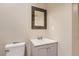 Cozy bathroom featuring a vanity with a mosaic-framed mirror and a white toilet at 6401 S Millbrook Way, Aurora, CO 80016