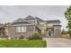 Beautiful two-story home featuring brick accents, manicured lawn, and lush landscaping for great curb appeal at 6401 S Millbrook Way, Aurora, CO 80016