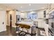 Modern white kitchen with stainless steel appliances, large island, and bar stool seating at 6401 S Millbrook Way, Aurora, CO 80016