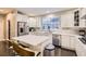 Bright white kitchen with marble backsplash, stainless appliances and dark hardwood floors at 6401 S Millbrook Way, Aurora, CO 80016