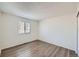 Minimalist bedroom with wood-look floors and natural light from a window at 2735 S Uravan St, Aurora, CO 80013