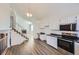Open kitchen with white cabinetry, stainless steel appliances, and modern lighting fixtures at 2735 S Uravan St, Aurora, CO 80013