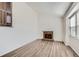 Bright living room with a red brick fireplace, large windows, and modern wood-look floors at 2735 S Uravan St, Aurora, CO 80013