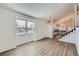 Bright living room with wood-look floors, large window, and stairs leading to the upper level at 2735 S Uravan St, Aurora, CO 80013