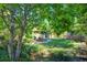 Landscaped backyard with a walking path, patio, and mature trees at 1339 Quince St, Denver, CO 80220