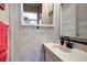 Cozy bathroom featuring vanity sink, a framed mirror, and a tiled wall at 1339 Quince St, Denver, CO 80220