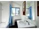 Cozy bathroom featuring a tub/shower combo, window, and vintage-style sink and mirror detail at 1339 Quince St, Denver, CO 80220
