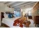 Stylish bedroom boasting exposed brick, wood beams, and a decorative arched doorway feature at 1339 Quince St, Denver, CO 80220
