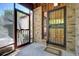 Entryway featuring a secure door, storm door, brick construction, and an outdoor living space at 1339 Quince St, Denver, CO 80220
