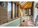 Charming sunroom with exposed brick walls, wood-framed windows, and tile flooring at 1339 Quince St, Denver, CO 80220