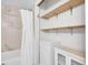 Compact bathroom boasts stylish shelving, a cabinet and a shower-tub combo with a curtain at 17505 E Mansfield Ave # 1412R, Aurora, CO 80013