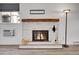 Close up on living room fireplace with decorative tools and a warm fire burning inside at 17505 E Mansfield Ave # 1412R, Aurora, CO 80013