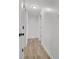 A bright hallway features neutral paint, modern light fixture, and wood-look flooring at 17505 E Mansfield Ave # 1412R, Aurora, CO 80013