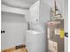 A well-organized laundry area featuring a stacked washer and dryer and a nearby hot water tank at 17505 E Mansfield Ave # 1412R, Aurora, CO 80013
