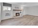 Cozy living room with a white brick fireplace, wood mantel, and light wood-look floors at 17505 E Mansfield Ave # 1412R, Aurora, CO 80013