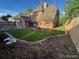 A well-manicured lawn in the backyard of a two-story brick home with a privacy fence and brick-lined garden beds at 911 Lincoln Pl, Boulder, CO 80302