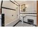 A well-lit bathroom boasts black and white tile, complemented by a pedestal sink and a bathtub with a shower at 911 Lincoln Pl, Boulder, CO 80302