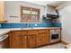 Kitchen featuring light wood cabinets, blue backsplash tiles, and modern appliances at 911 Lincoln Pl, Boulder, CO 80302