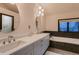 Bright bathroom featuring a double sink vanity and a tub with stylish tile surround at 6483 S Prince St, Littleton, CO 80120
