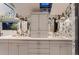 Bathroom featuring double sink vanity, modern fixtures, and stylish wallpaper at 6483 S Prince St, Littleton, CO 80120
