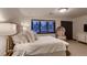 Bright bedroom with a luxurious bed, decorative chair, and large windows at 6483 S Prince St, Littleton, CO 80120