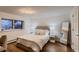 Bright bedroom featuring wood floors, neutral decor, and a large mirror at 6483 S Prince St, Littleton, CO 80120