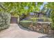 Exterior view of home with stone and wood accents, and well-maintained landscaping, on a hillside at 6483 S Prince St, Littleton, CO 80120