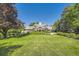 Stunning exterior elevation of a luxury home with lush landscaping and mature trees at 6483 S Prince St, Littleton, CO 80120