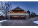 A two story home exterior featuring a stone facade and a large, attached two-car garage at 6483 S Prince St, Littleton, CO 80120