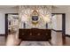 Elegant foyer with geometric wallpaper, stylish console table, and dark-stained hardwood floors at 6483 S Prince St, Littleton, CO 80120