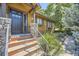 Inviting front entrance with stone accents, stained wood, and landscaped walkway to the door at 6483 S Prince St, Littleton, CO 80120