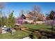 Landscaped front yard featuring beautiful blooming trees and an outdoor lounge space at 6483 S Prince St, Littleton, CO 80120