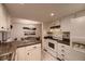 Well-lit kitchen with white cabinetry, granite countertops, and modern appliances at 6483 S Prince St, Littleton, CO 80120