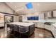 Modern kitchen with a large island, skylight, stainless steel appliances, and designer lighting fixtures at 6483 S Prince St, Littleton, CO 80120