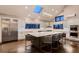 Bright kitchen featuring an expansive island with seating, white cabinetry, and modern stainless steel appliances at 6483 S Prince St, Littleton, CO 80120