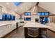 Gourmet kitchen with a central island, stainless steel range hood, and seamless transition to the living area at 6483 S Prince St, Littleton, CO 80120