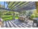 Spacious outdoor patio features a dining set under a pergola with views of a lush green lawn at 6483 S Prince St, Littleton, CO 80120