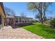 Backyard featuring a red brick sunroom, green grass, and a red brick patio at 11609 Fowler Dr, Northglenn, CO 80233