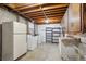 Basement laundry area with washer, dryer, shelving, and exposed ceiling beams at 11609 Fowler Dr, Northglenn, CO 80233
