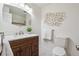 This bathroom features a white marble floor, white walls, and a wooden vanity at 11609 Fowler Dr, Northglenn, CO 80233
