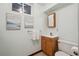 Cozy bathroom with a wood vanity, framed mirror, and natural light from the window at 11609 Fowler Dr, Northglenn, CO 80233