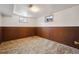 This bedroom features wood paneling, carpet, and two windows at 11609 Fowler Dr, Northglenn, CO 80233