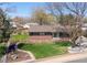 Landscaped front yard with brick home, mature trees, and a well-maintained lawn at 11609 Fowler Dr, Northglenn, CO 80233