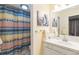 Well-lit bathroom with a decorative shower curtain and whale themed artwork at 3709 S Fairplay Way, Aurora, CO 80014