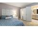 Bedroom with a woven headboard and access to bathroom with a mirrored cabinet at 3709 S Fairplay Way, Aurora, CO 80014
