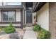 Close-up of the front entry with lovely plants, a chair, and a view of the stained front door at 3709 S Fairplay Way, Aurora, CO 80014
