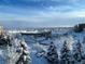 Aerial view of the community covered in snow, with buildings and snow covered trees at 5677 S Park Pl # 311A, Greenwood Village, CO 80111